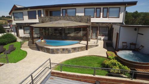 ein Haus mit Pool im Hinterhof in der Unterkunft Dein Haus Hotel y Departamentos in Puerto Varas