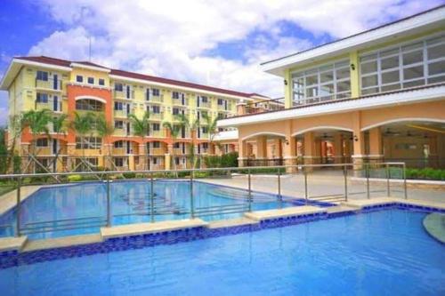 einem großen Pool vor einem Gebäude in der Unterkunft Cozy Condo with Swimming Pool, WIFI & Netflix good for 4PAX in Davao City