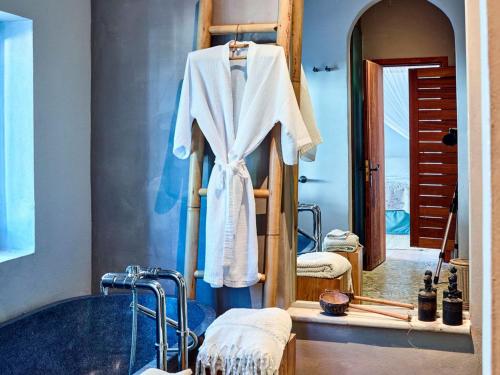 een badkamer met een badjas aan een handdoekenrek bij Beautiful villa for 12 people in San Jose de sa Talaia