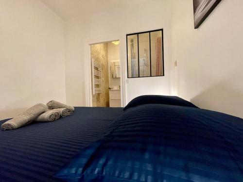 a bedroom with a blue bed with two towels on it at Le Petit Balcon de Verdun - Carcassonne centre in Carcassonne