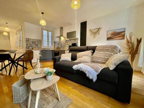 a living room with a black couch and a table at Le Petit Balcon de Verdun - Carcassonne centre in Carcassonne
