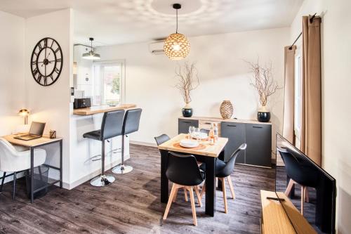 une cuisine et une salle à manger avec une table et des chaises dans l'établissement Bel appartement tout confort en Aveyron, à Firmi