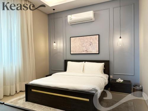 a bedroom with a bed with white sheets and a ceiling at Kease Al-Mutamarat A-5 Timeless History AG76 in Riyadh