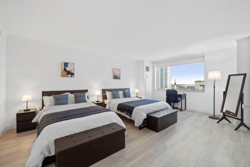 a bedroom with two beds and a large window at Modern 2BR 3BA Condo on the Boardwalk by CozySuites in Atlantic City