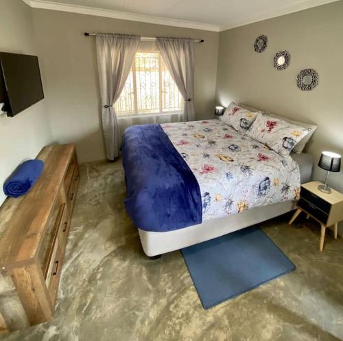 a bedroom with a large bed and a window at Stellies Accommodation - Room 1 in Keetmanshoop