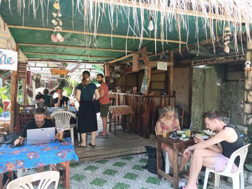 een groep mensen die aan tafel zitten in een restaurant bij P P Garden Home Bungalow in Phi Phi Don