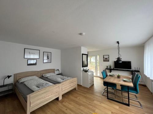 ein Schlafzimmer mit einem Bett, einem Tisch und einem Schreibtisch in der Unterkunft Obstgarten am Bodensee in Bermatingen