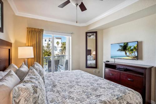 Schlafzimmer mit einem Bett und einem Flachbild-TV in der Unterkunft Sunset Vistas 313N in St Pete Beach