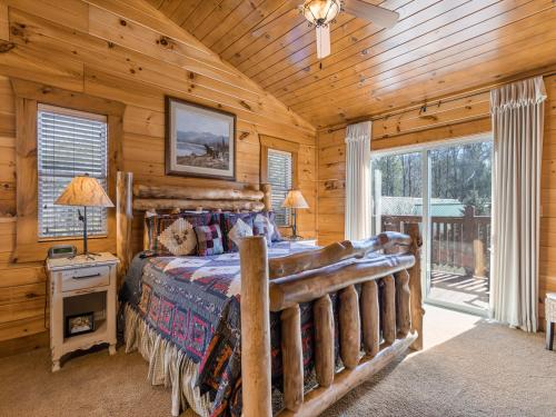 a bedroom with a bed in a log cabin at Rainbows End in Gatlinburg