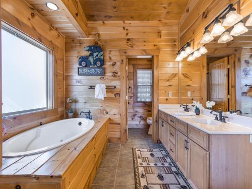 a log cabin bathroom with two sinks and a tub at Rainbows End in Gatlinburg