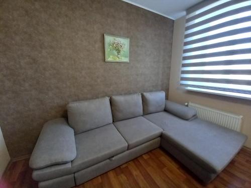 un sofá en una sala de estar con ventana en Prometey Hotel, en Dniprodzerzhynsʼk