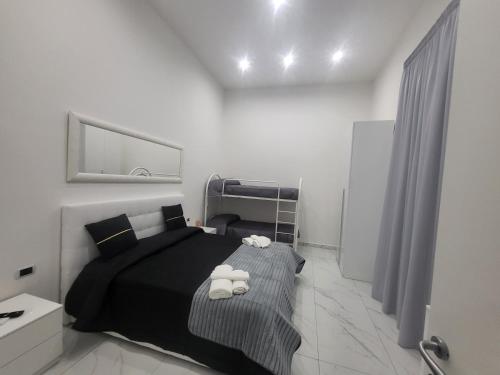 a bedroom with a black bed and a mirror at Live Naples in Naples
