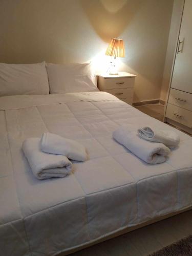 sypialnia z białym łóżkiem i ręcznikami w obiekcie Maria’s apartment w mieście Amfilochia