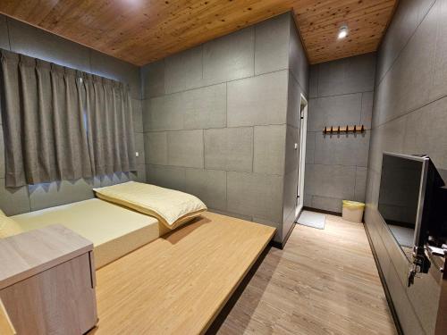 1 dormitorio con 2 camas y TV en 正記製茶所民宿, en Le-yeh