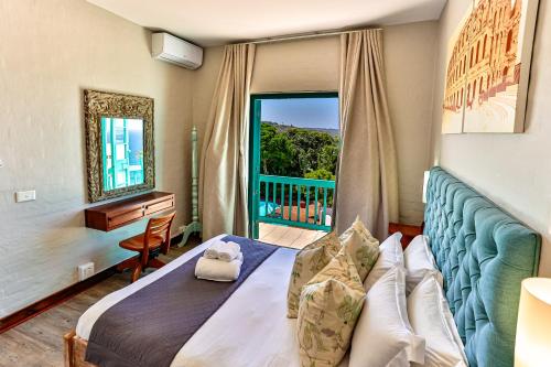 a bedroom with a bed and a window and a desk at 10 AKROTIRI, SANTORINI ESTATE - Families only in Ballito