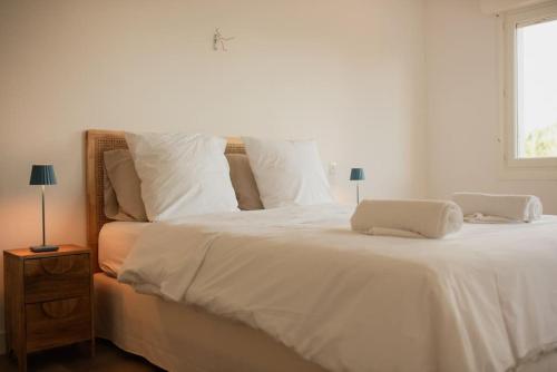 - un lit blanc avec un ordinateur portable dans l'établissement Appartement La Case, à Soorts-Hossegor