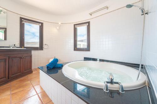 baño grande con bañera y lavamanos en La Asomada Suite Moon Lanzarote, en Tías