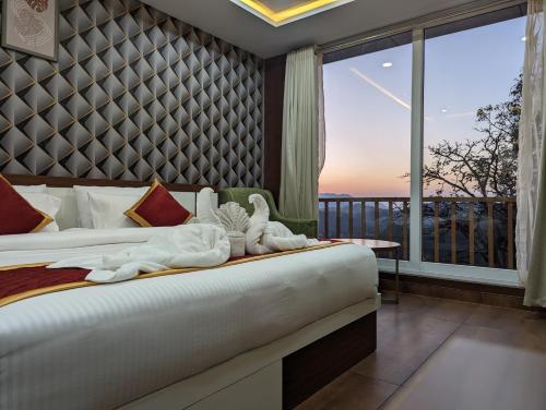 a bedroom with a bed and a large window at OXYRICH in Madikeri