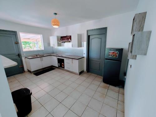 a kitchen with a counter and a refrigerator in it at Le Nil Appartement Cosy tout confort in Baie-Mahault