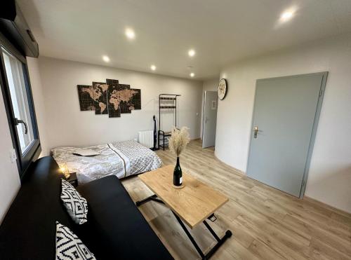 une chambre avec un lit et une table dans une pièce dans l'établissement Studio champenois, à Nogent-lʼArtaud