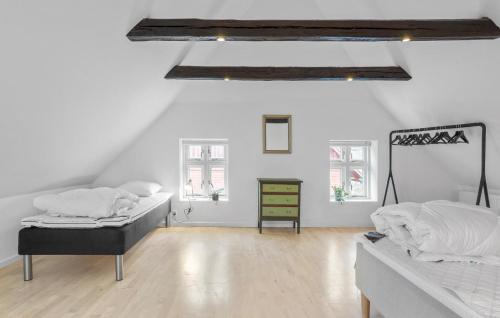 Duas camas num quarto com paredes brancas e pisos em madeira em Nice Home In Roslev With Kitchen em Roslev