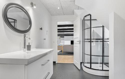 uma casa de banho branca com um lavatório e um espelho em Nice Home In Roslev With Kitchen em Roslev