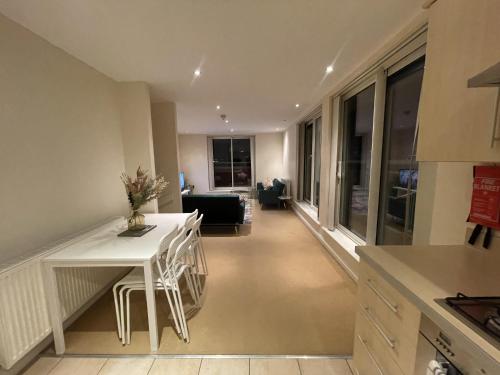 cocina y sala de estar con mesa blanca y sillas en Free parking near city centre & stadium sleeps 6-8 en Leicester
