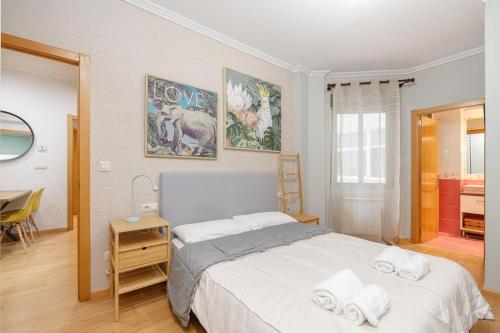 Un dormitorio con una cama grande y una mesa con una silla en Cómodo y moderno piso en Vigo by CABANA Rentals en Vigo