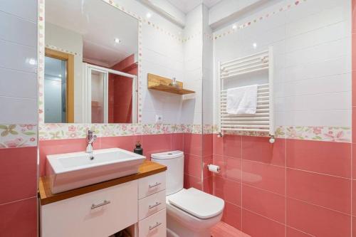 Baño rosa con lavabo y aseo en Cómodo y moderno piso en Vigo by CABANA Rentals en Vigo