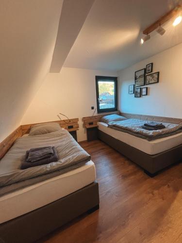 twee bedden in een kamer met een raam bij Spessart Chalet in Dammbach