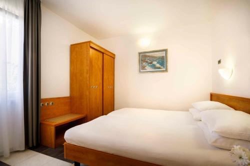 a bedroom with two beds and a wooden cabinet at Apartment in Rovinj - Istrien 47029 in Rovinj