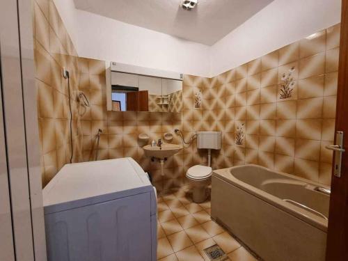 een badkamer met een bad, een toilet en een wastafel bij Apartment in Njivice - Insel Krk 47352 in Njivice