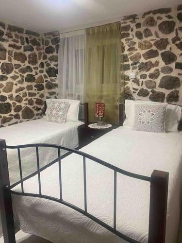 1 dormitorio con 2 camas y pared de piedra en Lovely Apartment in Litoxoro en Litóchoron