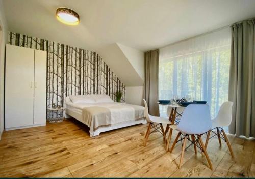 a bedroom with a bed and a table and chairs at Apartamenty Spacerowa 27 in Niechorze