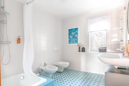 a white bathroom with a toilet and a sink at Tuyo Casa Sarabandy in Warsaw