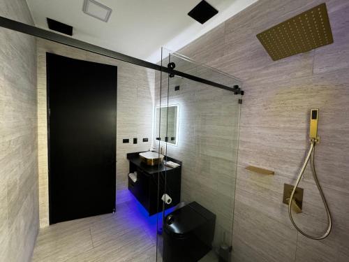 uma casa de banho com um chuveiro e uma porta preta em Luxury Condo at Los Sueños Resort & Marina em La Mona