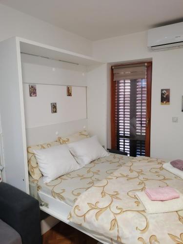 une chambre avec un grand lit dans une pièce dans l'établissement Apartman Lala, à Vrnjačka Banja