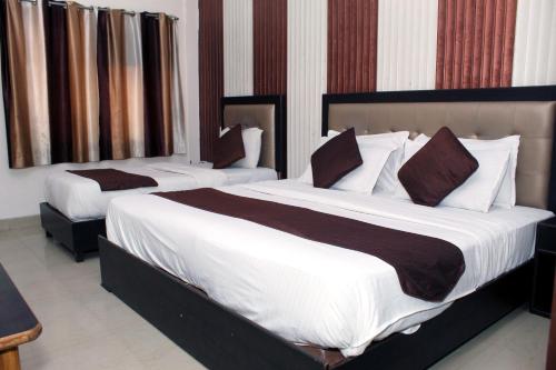 two beds in a hotel room at Hotel Anand in Haridwār