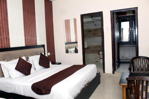 a bedroom with a large bed and a bathroom at Hotel Anand in Haridwār