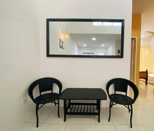 a table and two chairs and a mirror on a wall at WawAmir Homestay @ Seri Iskandar in Seri Iskandar