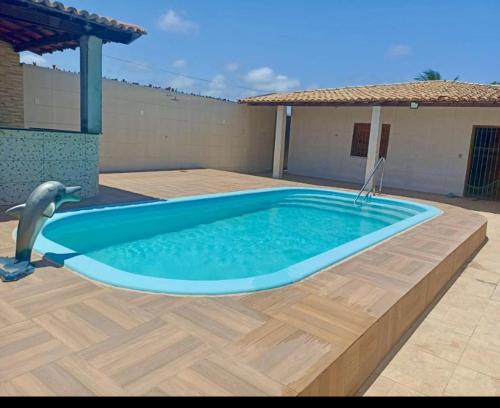 a swimming pool with a dolphin in a yard at Chácara Santana 03 quartos in Aracaju