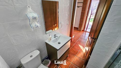 a bathroom with a toilet and a sink and a mirror at Villa Laura in Alhaurín el Grande