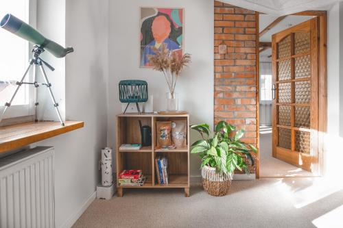 a living room with a book shelf with a plant at Tuyo Casa Sarabandy in Warsaw