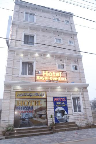 um grande edifício branco com um cartaz em Hotel Royal Comfort em Lahore