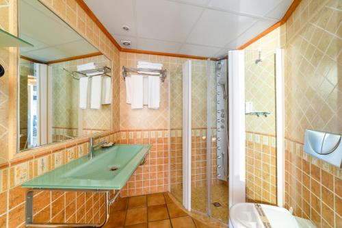 HOTEL EL CASTELL في فالديروبريس: حمام مع حوض أخضر ودش