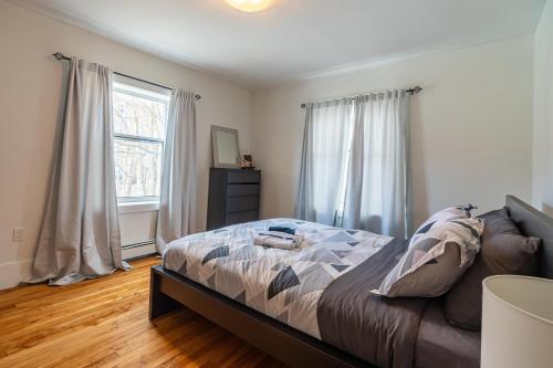 a bedroom with a bed and two windows at Beautiful & Spacious Apt #101 in Halifax