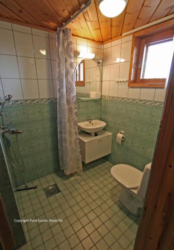 a bathroom with a shower and a toilet and a sink at Holidayhome Hoviranta in Luosto