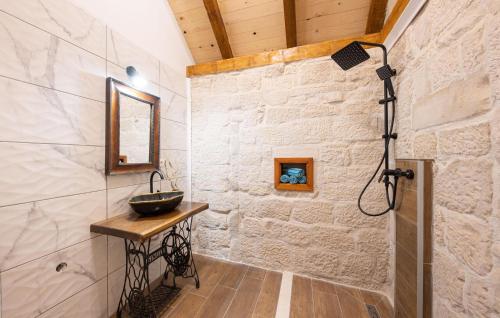een badkamer met een wastafel in een stenen muur bij 2 Bedroom Amazing Home In Obrovac Sinjski in Obrovac Sinjski