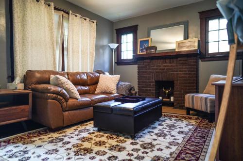 sala de estar con sofá de cuero y chimenea en Entire Townhouse - 2 Separate Units, en Covington
