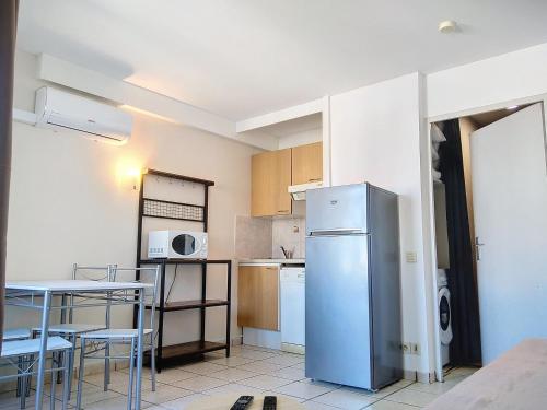 eine Küche mit einem Kühlschrank sowie einem Tisch und Stühlen in der Unterkunft Résidence Graziella Studio 624 in Juan-les-Pins